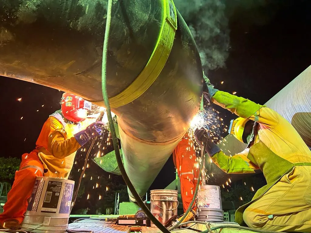 Cuadrilla de soldadura certificada trabajando en tubería industrial de noche